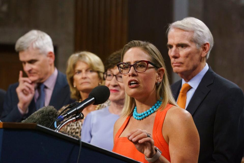 Sen. Kyrsten Sinema (center), D-Ariz., joined from left by, Sen. Bill Cassidy, R-La., Sen. Lisa Murkowski, R-Alaska, Sen. Susan Collins, R-Maine, and Sen. Rob Portman, R-Ohio, speak to reporters just after a vote to start work on a nearly $1 trillion bipartisan infrastructure package, at the Capitol in Washington, July 28, 2021.