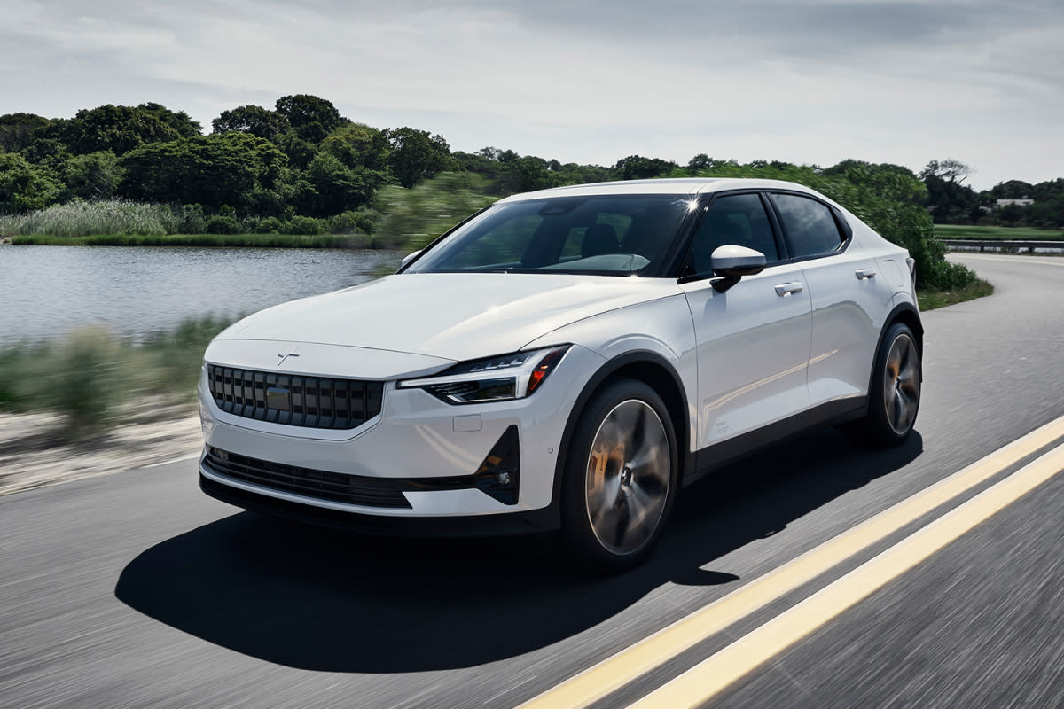 The Polestar 2 EV driving down the road next to a lake