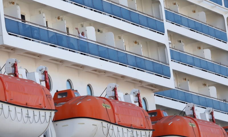 A passenger waves from MSC Fantasia cruise ship in Lisbon