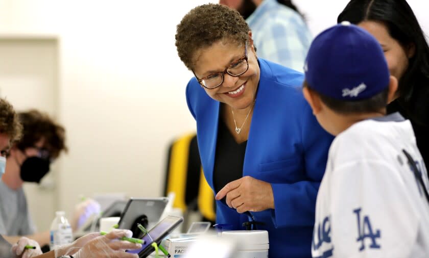 Mayoral candidate Karen Bass, center, checks in to vote with her grandson Henry Depaz.