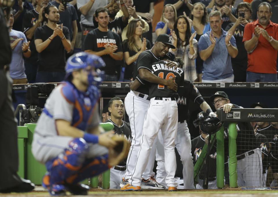 Dee Gordon embracing Marlins hitting coach Barry Bonds after his leadoff homer. (AP)