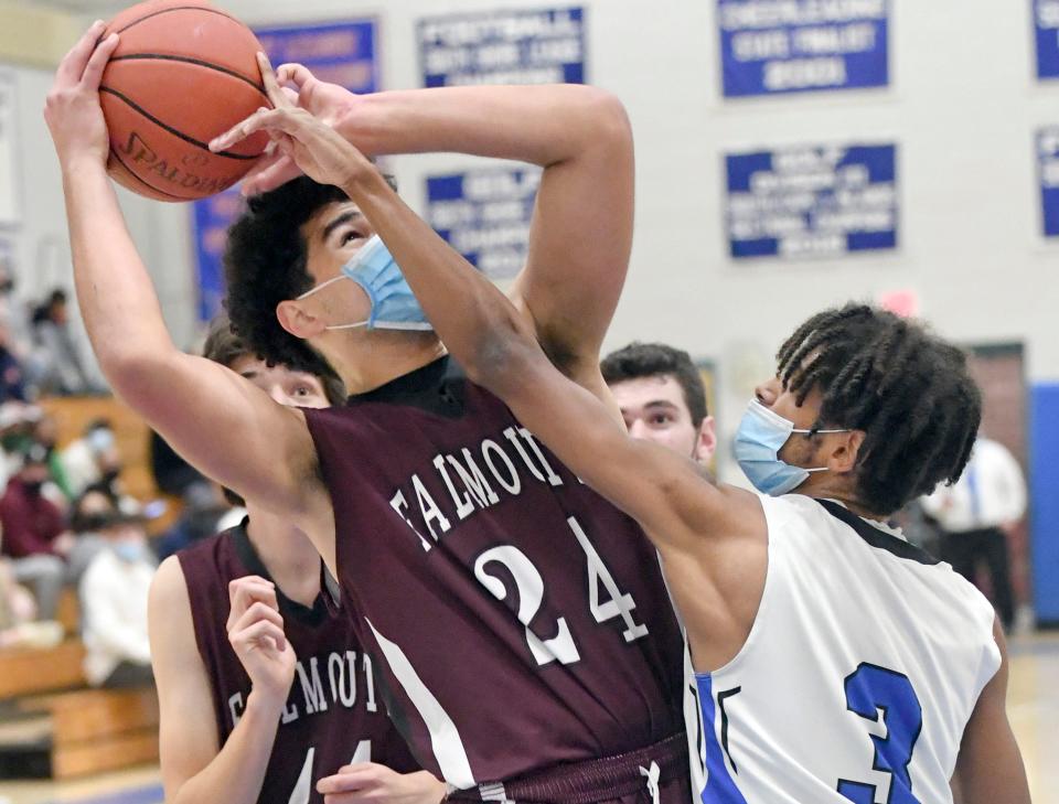 In this December 2021 game, Otis Longman of Mashpee gets his finger on the ball being shot by Jayden Bernhardt of Falmouth