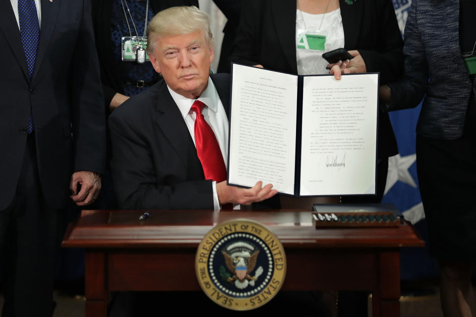 Trump holds up a signed executive order at the Department of Homeland Security on&nbsp;Jan. 25, 2017.&nbsp;