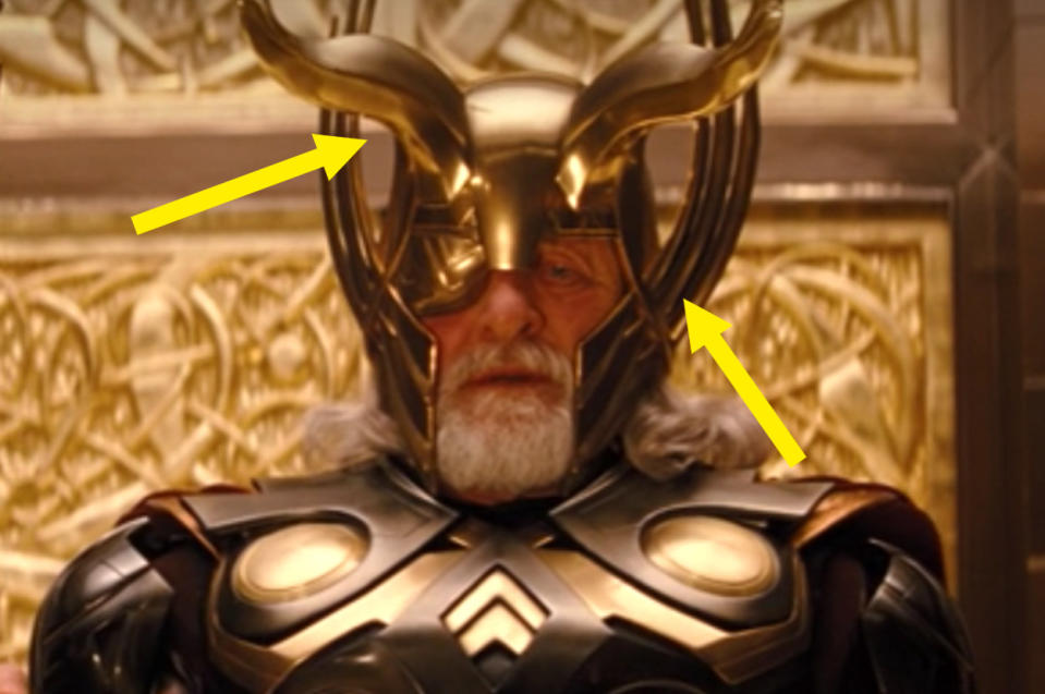 Odin wearing his ornate helmet that has long wings that go up the sides on the cheek and horns that curve coming out the front