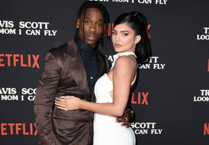 Travis and Kylie with their arms around each other as they pose for a photo at a red carpet event