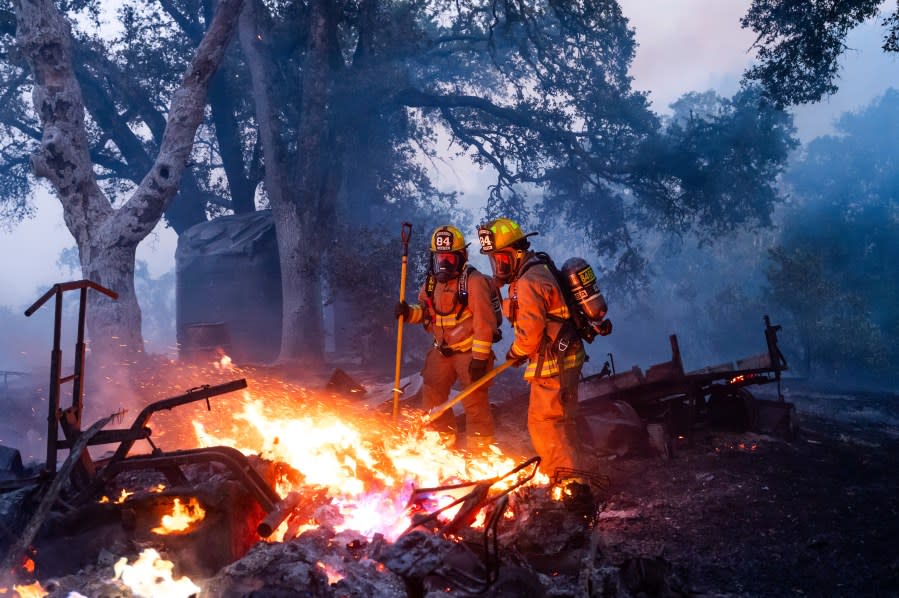 Firefighters extinguish a burning outbuilding as the Point Fire spreads along West Dry Creek Rd. in Healdsburg, Calif., on Sunday, June 16, 2024. (AP Photo/Noah Berger)
