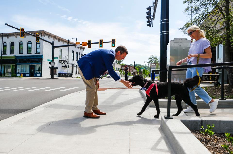 Gov. Andy Beshear pets dog Winnie as his wife and First Lady Britainy Beshear leave the polling precinct in downtown Frankfort for this year's primary election for Governor during early voting Thursday in Frankfort, Ky. May, 11, 2023.