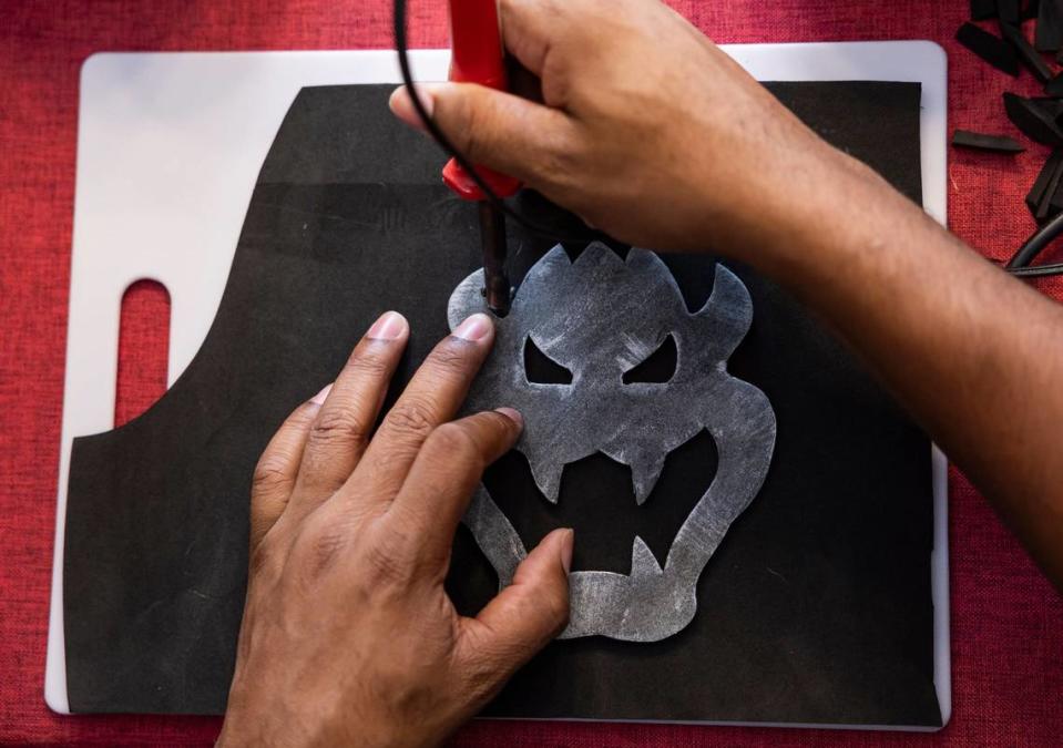 Matthew Harden uses a stencil to cut a piece of foam for a costume for Florida Supercon.