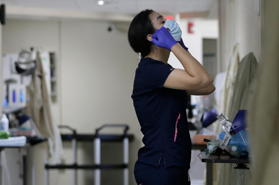 Certified Nursing Assistant Angelica Corral changes her personal protective equipment as she travels from room to room at the El Paso Long Term Acute Care hospital on Nov. 6, 2020.