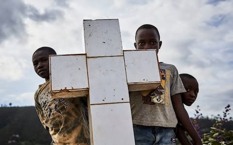 Local boys look at the funeral of Ebola victims - 1,147 people have so far died - Credit: HUGH KINSELLA CUNNINGHAM/EPA-EFE/REX