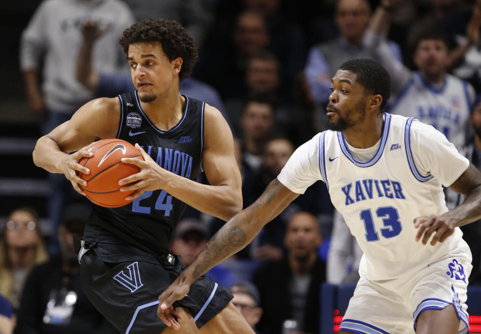 Villanova forward Jeremiah Robinson-Earl (24) is pressured by Xavier forward Naji Marshall (13) during the second half of an NCAA college basketball game, Saturday, Feb. 22, 2020, in Cincinnati. (AP Photo/Gary Landers)