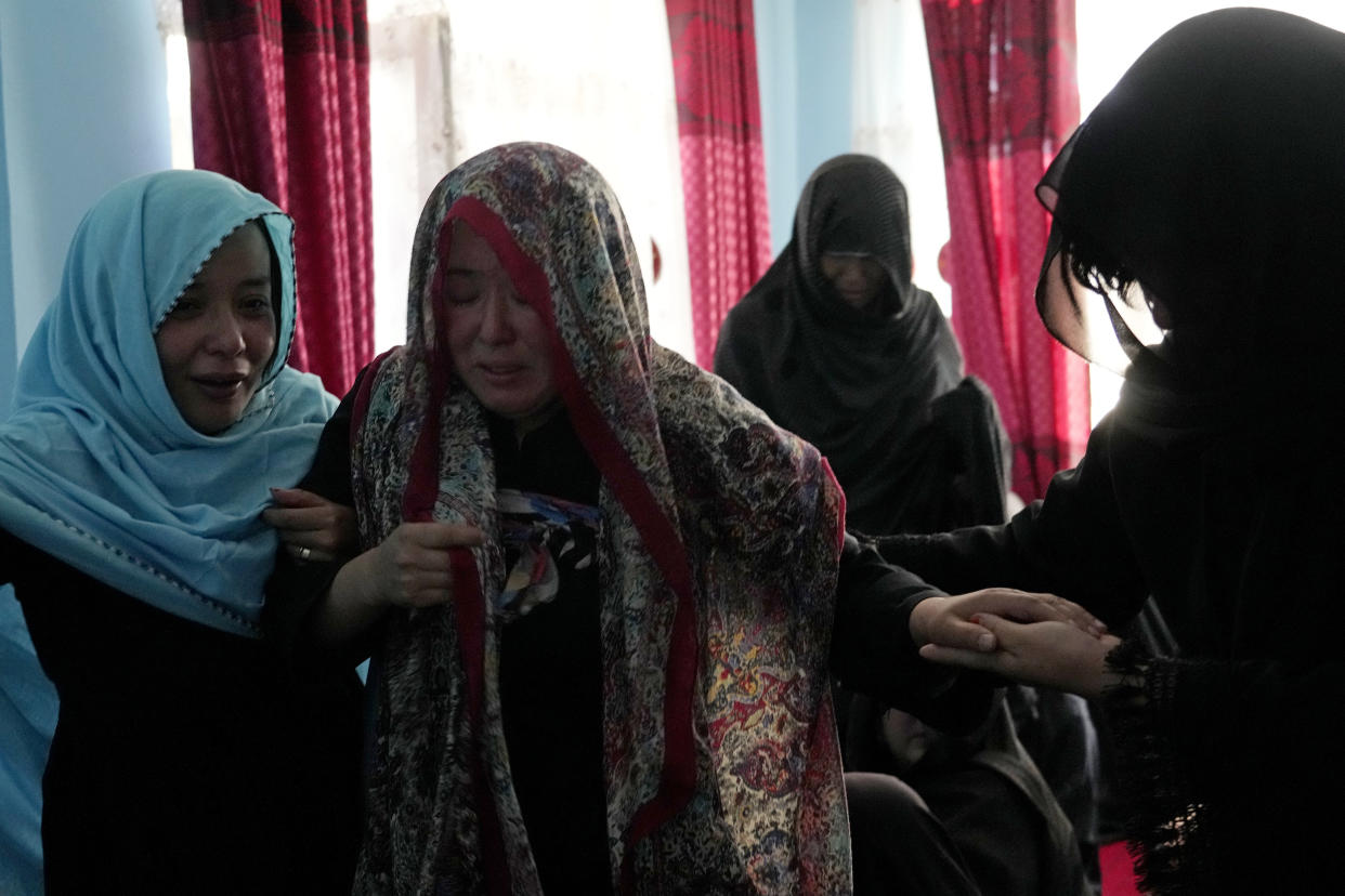 The family of a 19-years old girl who was victim of a suicide bomber mourns, in Kabul, Afghanistan, Friday, Sept. 30, 2022. A Taliban spokesman says a suicide bomber has killed several people and wounded others at an education center in a Shiite area of the Afghan capital. The bomber hit while hundreds of teenage students inside were taking practice entrance exams for university, a witness says. (AP Photo/Ebrahim Noroozi)