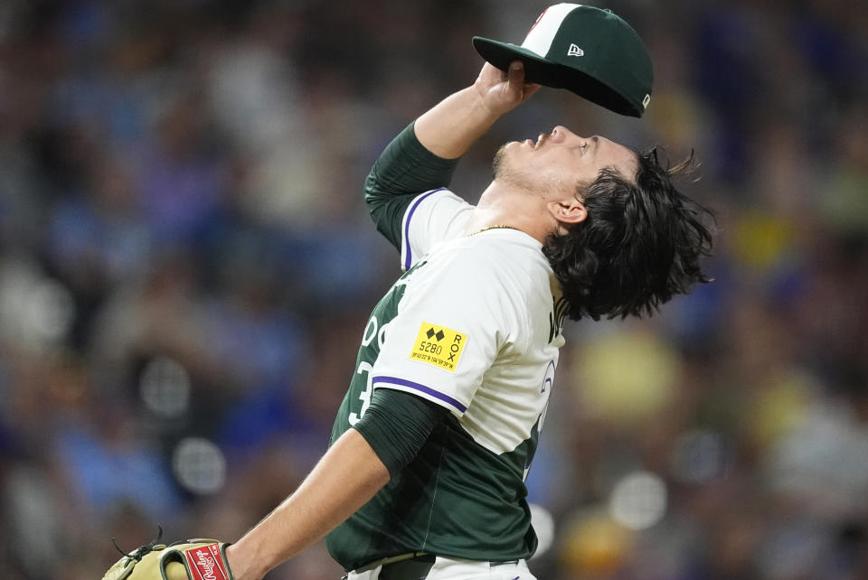 Colorado Rockies relief pitcher Victor Vodnik adjusts his cap before facing Kansas City Royals' Freddy Fermin in the ninth inning of a baseball game Saturday, July 6, 2024, in Denver. (AP Photo/David Zalubowski)