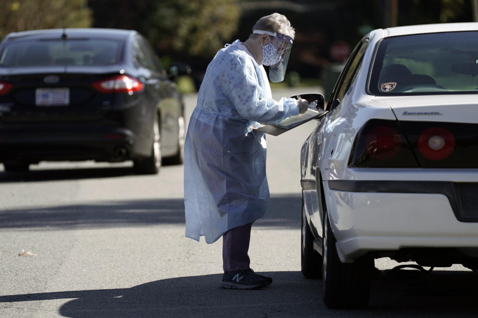 FILE - In this Nov. 3, 2020, file photo, a poll worker assists a drive-thru voter at the Graham Civic Center polling site in Graham, N.C. In 2020, election officials tried to make voting easier and safer amid a global pandemic. Next time, they might get fined or face criminal charges. (AP Photo/Gerry Broome, File)