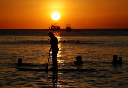 Tourists frolic on the water during sunset, two days before the temporary closure of the holiday island Boracay in the Philippines April 24, 2018. REUTERS/Erik De Castro