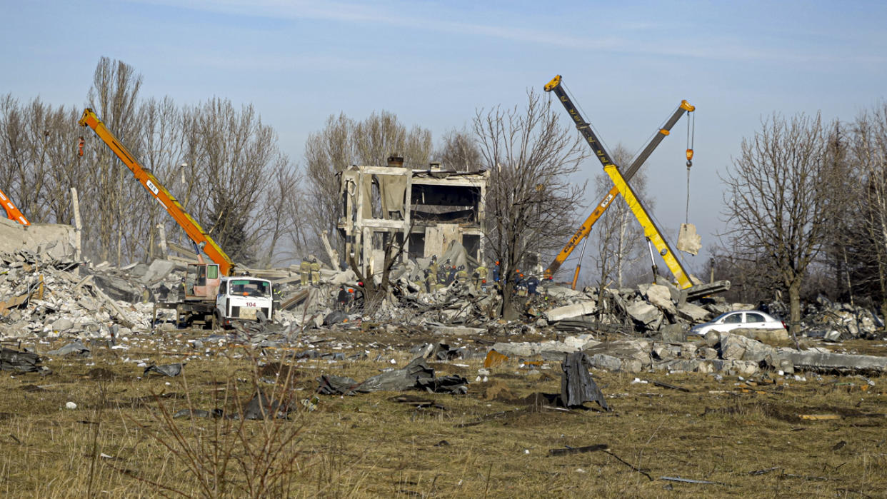 Workers clean rubble after a Ukrainian rocket strike in Makiivka, in the Russian-controlled Donetsk region in eastern Ukraine on Tuesday. Russia's Defense Ministry says 63 of its soldiers were killed. (AP)