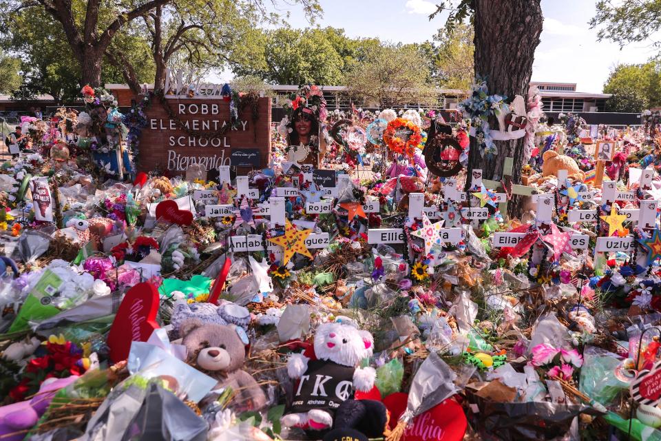 Flowers and crosses cover the front lawn at Robb Elementary, where 19 children and two teachers were gunned down on May 24.