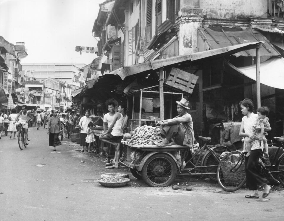 A black and white photo of a bustling street in Singapore in 1962.