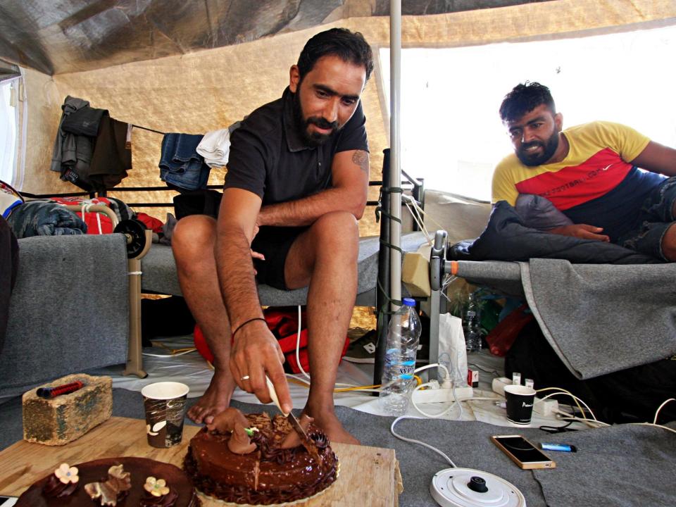 The Syrian refugee cuts his birthday cake in the tent he has called home for the last four months: Charlie Faulkner/The Independent