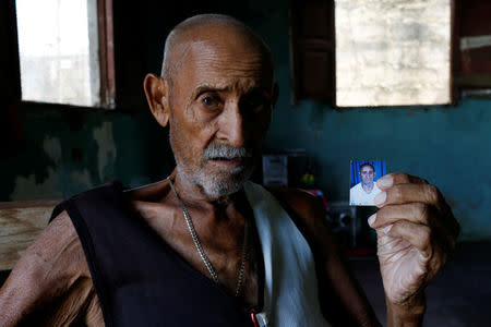 Juan Pulgar, 73, holds a picture of himself taken about a year ago, as he poses for a portrait in his house in Punto Fijo, Venezuela November 17, 2016. REUTERS/Carlos Garcia Rawlins