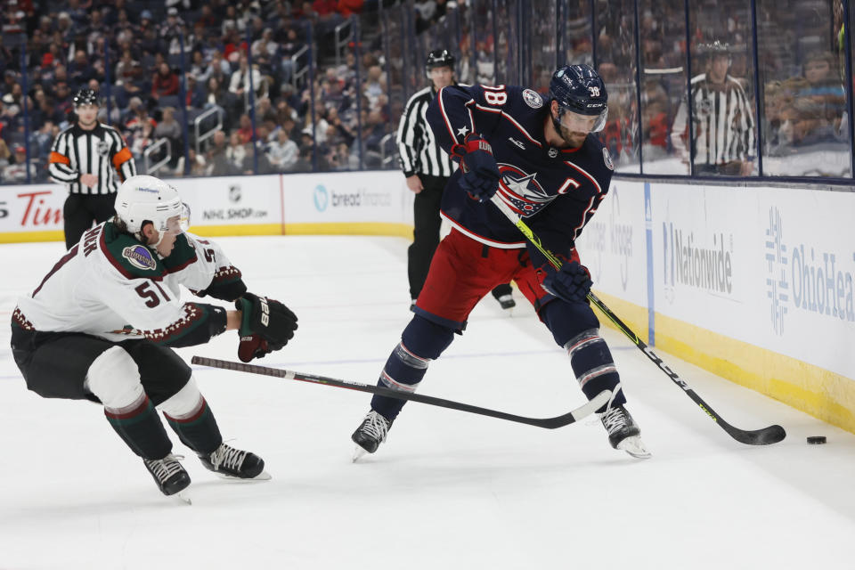 Columbus Blue Jackets' Boone Jenner, right, controls the puck as Arizona Coyotes' Troy Stecher defends during the second period of an NHL hockey game Tuesday, Oct. 25, 2022, in Columbus, Ohio. (AP Photo/Jay LaPrete)