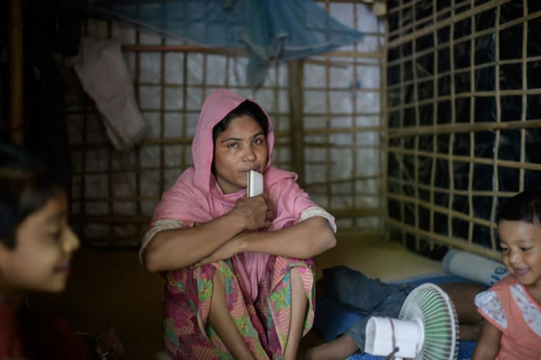 Mabia Khatun sits between her children the day after her husband Najmul Islam died in a roadside shack at the Kutupalong refugee camp near Cox's Bazar