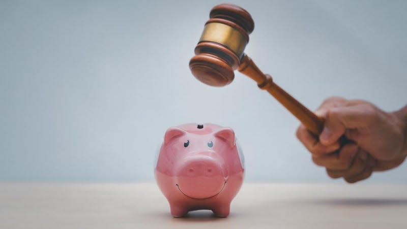 A judges gavel striking a piggy bank. I love my screenreader friends.