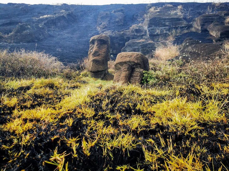 Las estatuas Moai dañadas se ven después de un incendio forestal en un parque local en Isla de Pascua, Chile