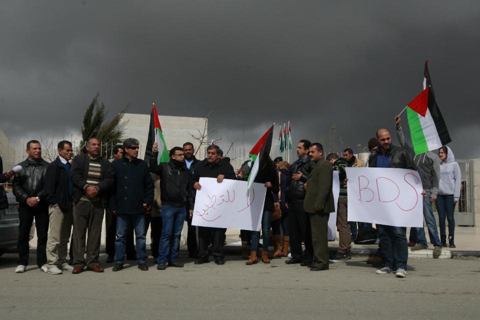 Palestinians protesters holding national flags and banners participate in a demonstration against the visit of Israeli students and activists to Palestinian President Mahmoud Abbas, in the West Bank city of Ramallah, Sunday, Feb. 16, 2014. The Palestinian president told hundreds of young Israeli activists on Sunday that he does not want to “drown” Israel with Palestinian refugees, in his most conciliatory comments to date on one of the thorniest issues in Mideast peace talks. Arabic on banner reads, "No to normalization." (AP Photo/Majdi Mohammed)