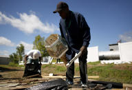 Joseph Watson gathers a few belongings from a storage shed that was destroyed when a tornado touched down in Windsor, N.C. during the early hours of Tuesday, Aug. 4, 2020. (Stephen M. Katz/The Virginian-Pilot via AP)