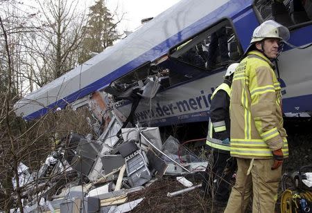 Rescuers stand in front of a carriage at the site of the two crashed trains near Bad Aibling in southwestern Germany, February 9, 2016. REUTERS/Josef Reisne