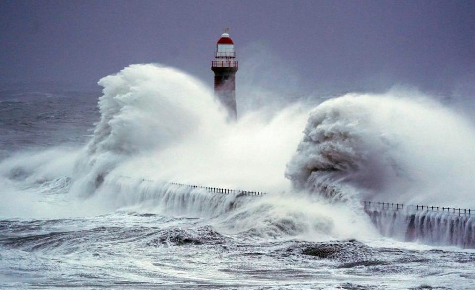 Huge waves crash the against the sea wall and Roker Lighthouse in Sunderland on Saturday morning (Owen Humphreys/PA) (PA Wire)