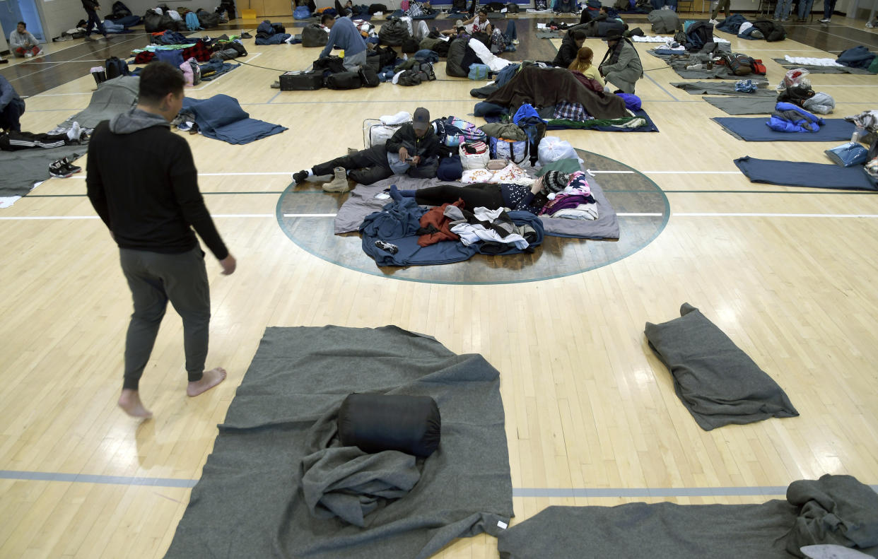 Migrants rest at a makeshift shelter in Denver on Friday, Jan. 6, 2023. Over the past month, nearly 4,000 immigrants, almost all Venezuelans, have arrived unannounced in the frigid city, with nowhere to stay and sometimes wearing T-shirts and flip-flops. In response, Denver converted three recreation centers into emergency shelters for migrants and paid for families with children to stay at hotels, allocating $3 million to deal with the influx. (AP Photo/Thomas Peipert)