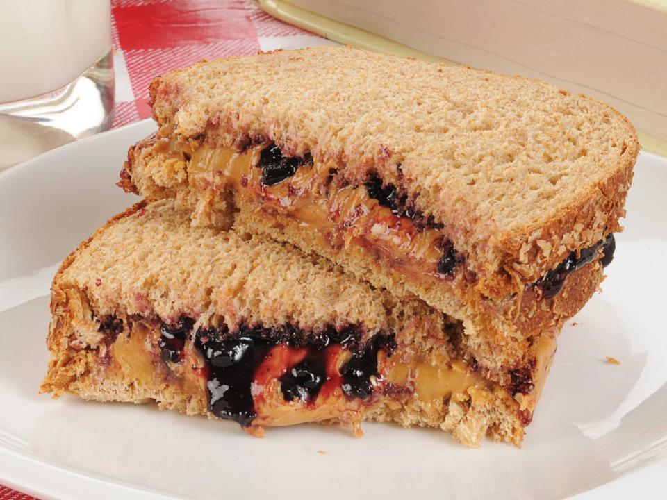 peanut butter and jelly sandwich halves stacked on a plate