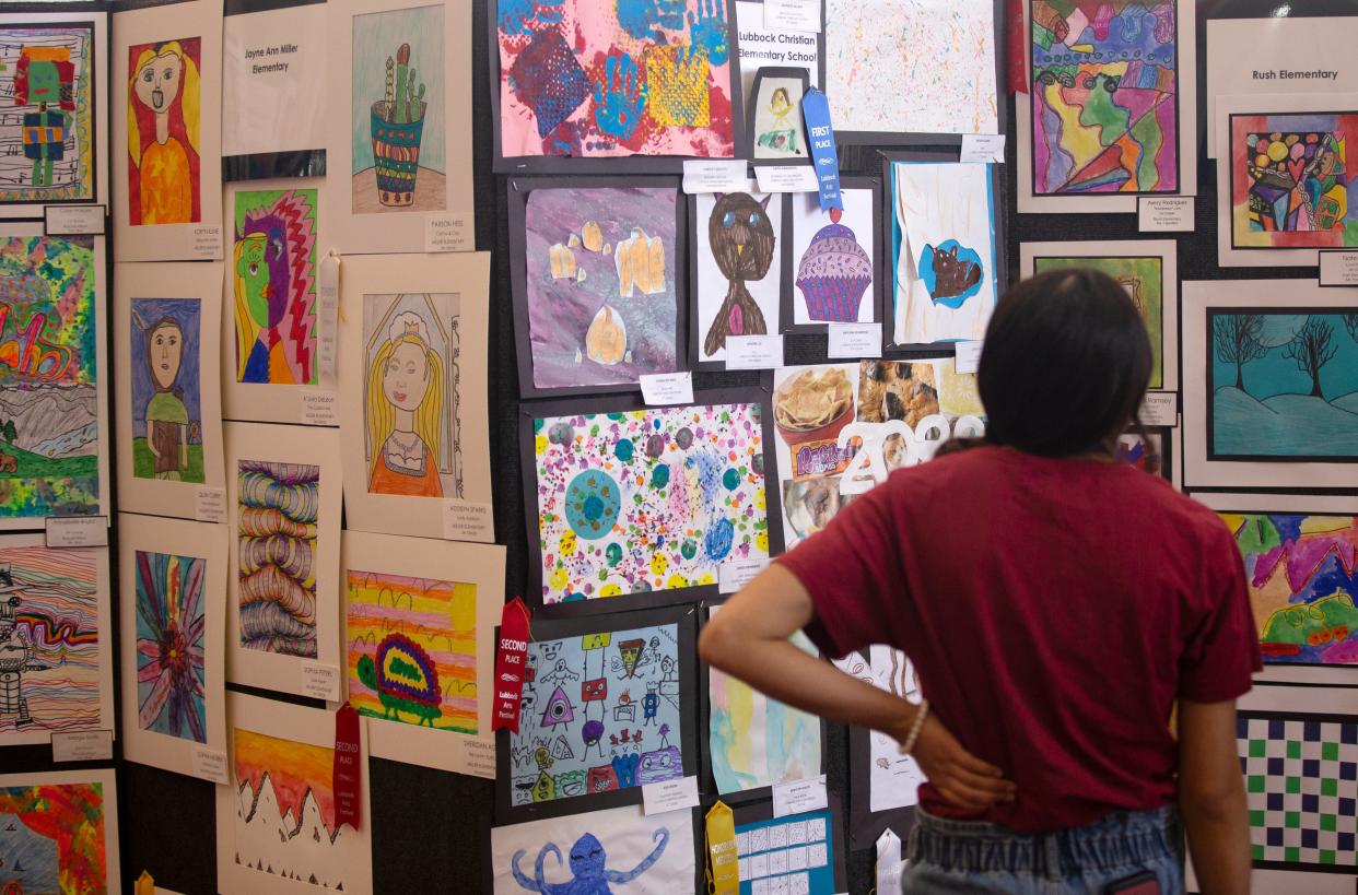 An attendee looks at art from Lubbock Christian Elementary School at the Lubbock Arts Festival, Saturday, April 9, 2022, at Lubbock Memorial Civic Center. Attendees could create or purchase art through various exhibits.