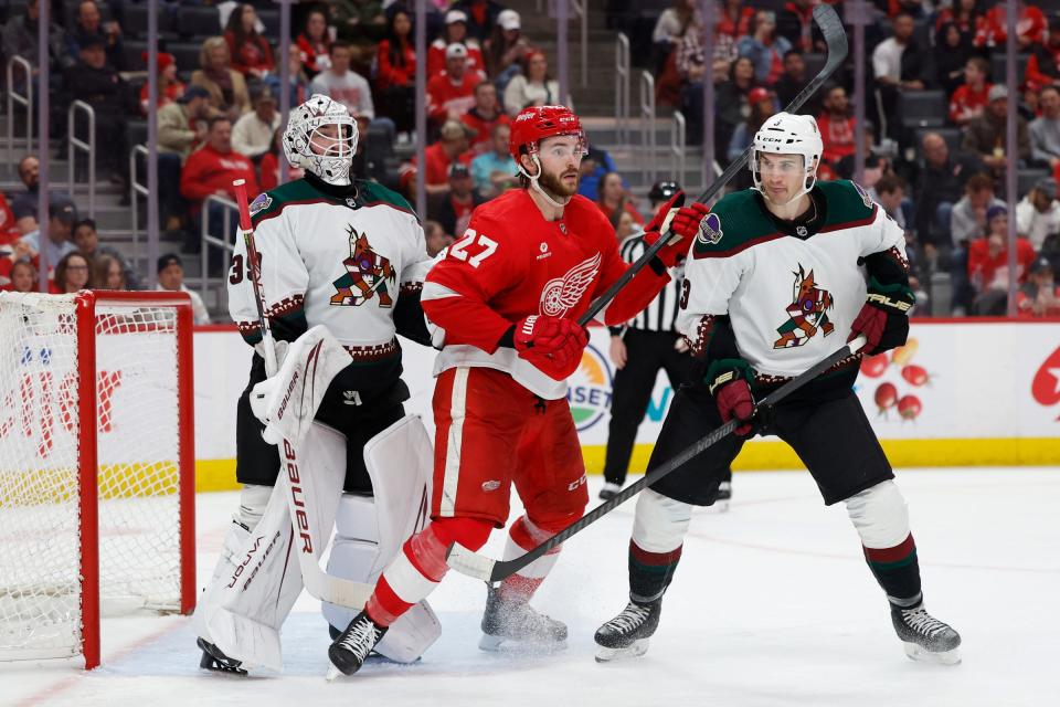 Red Wings center Michael Rasmussen and Coyotes defenseman Josh Brown fight for position in front of goaltender Connor Ingram in the second period on Thursday, March 14, 2024, at Little Caesars Arena.