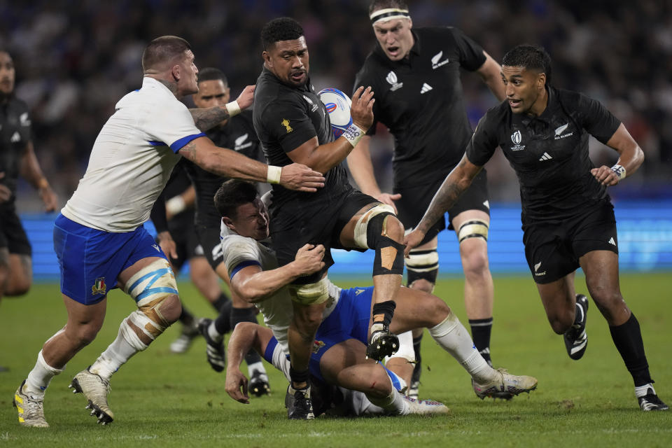 New Zealand's Ardie Savea, center, challenges for the ball during the Rugby World Cup Pool A match between New Zealand and Italy at the OL Stadium in Lyon, France, Friday, Sept. 29, 2023. (AP Photo/Pavel Golovkin)