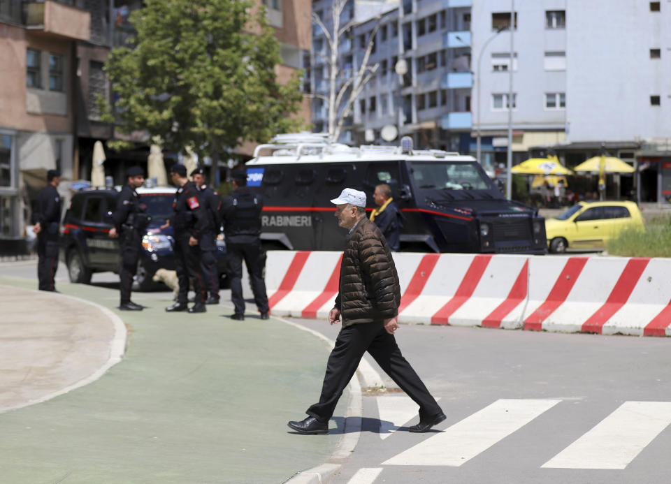 A man walks by Italian Carabinieri of the NATO-led Kosovo Force Mission (KFOR) securing the main bridge in northern Serb-dominated part of ethnically divided town of Mitrovica, Kosovo, Tuesday, May 28, 2019. KFOR is calling on all people in the country to stay calm, adding that it is closely monitoring a police operation in the north after a Kosovo police operation against organized crime in the north, where most of the ethnic Serb minority lives, has sparked tension, and Serbia ordered its troops to full alert. (AP Photo/Bojan Slavkovic)