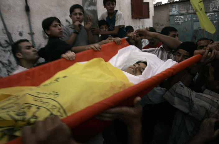 FILE - Palestinian mourners carry the body of Ahmed Abu Zeibeida, 13, during his funeral at the Jebaliya refugee camp in the northern Gaza Strip, Friday, June 1, 2007. Rights groups said Thursday. Dec. 2, 2021, that Israel failed to investigate shootings that killed more than 200 Palestinians and wounded thousands at violent protests along the Gaza frontier in recent years, strengthening the case for the International Criminal Court to intervene. (AP Photo/Hatem Moussa, File)