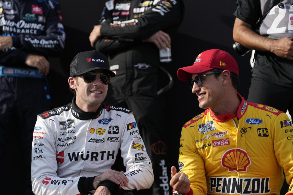 Ryan Blaney, left and Joey Logano, right, wait for driver introductions before a NASCAR Cup Series auto race at Atlanta Motor Speedway on Sunday, July 9, 2023, in Hampton, Ga. (AP Photo/Brynn Anderson)