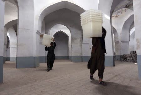 Afghan election commission workers carry ballot boxes at a polling station at a mosque in Herat June 13, 2014. The second round of Afghanistan's presidential election will take place on Saturday. REUTERS/Mohmmad Shoib