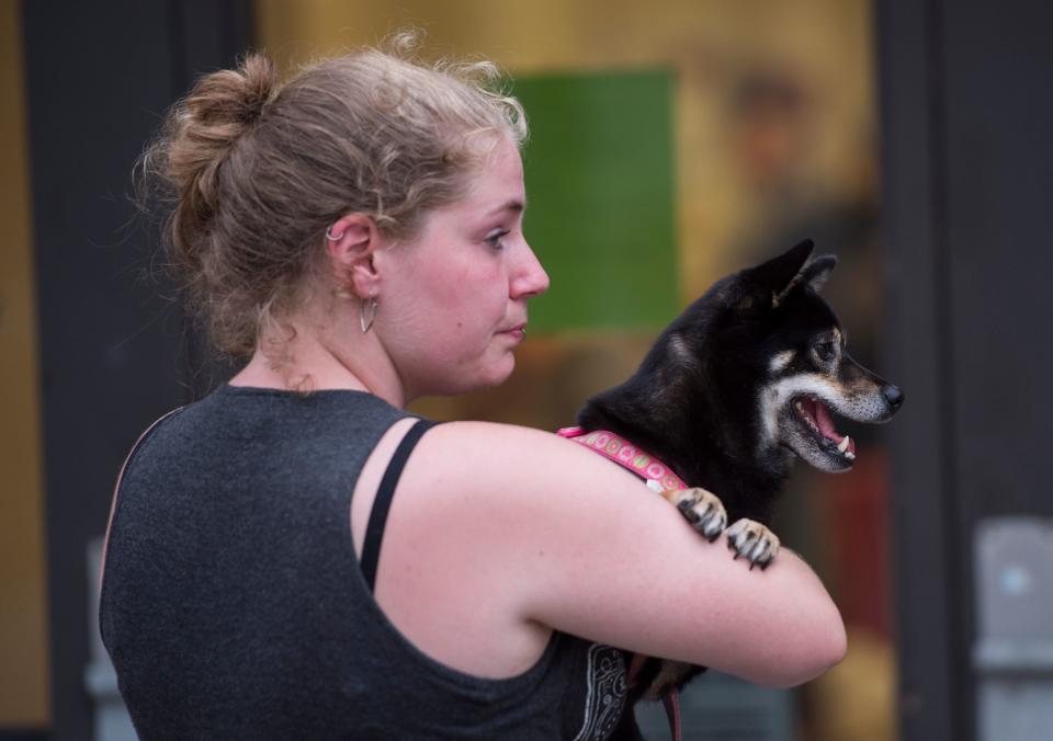 A woman holds her dog as she waits to enter a hurricane shelter at Trask Middle School in Wilmington, North Carolina, on September 11, 2018.&nbsp;