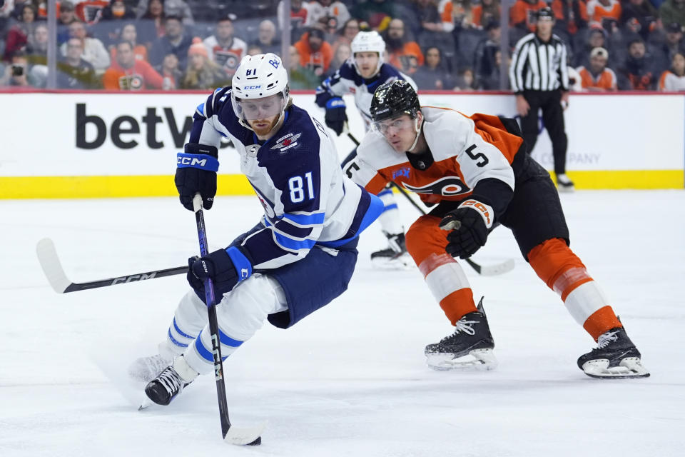 Winnipeg Jets' Kyle Connor, left, tries to keep the puck away from Philadelphia Flyers' Egor Zamula during the third period of an NHL hockey game, Thursday, Feb. 8, 2024, in Philadelphia. (AP Photo/Matt Slocum)