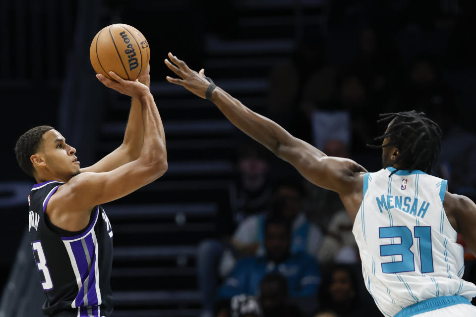 Sacramento Kings forward Keegan Murray , left, looks to shoot over Charlotte Hornets center Nathan Mensah (31) during the first half of an NBA basketball game in Charlotte, N.C., Wednesday, Jan. 10, 2024. (AP Photo/Nell Redmond)