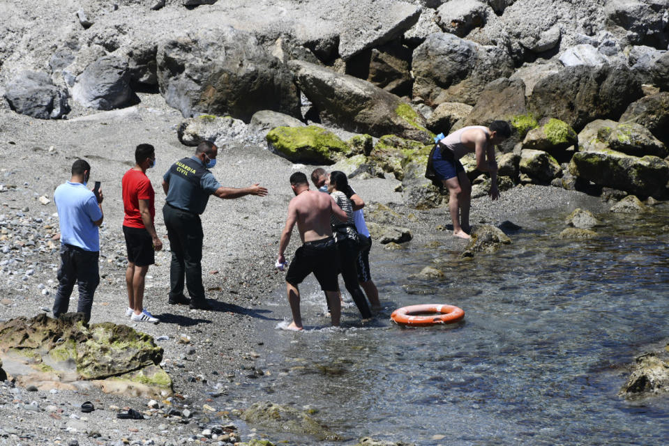 A woman from Morocco arrives at the beach after swimming crossing into the Spanish territory, near the border of Morocco and Spain at the Spanish enclave of Ceuta on Monday, May 17, 2021. Authorities in Spain say that around 1,000 Moroccan migrants have crossed into Spanish territory (Antonio Sempere/Europa Press via AP)