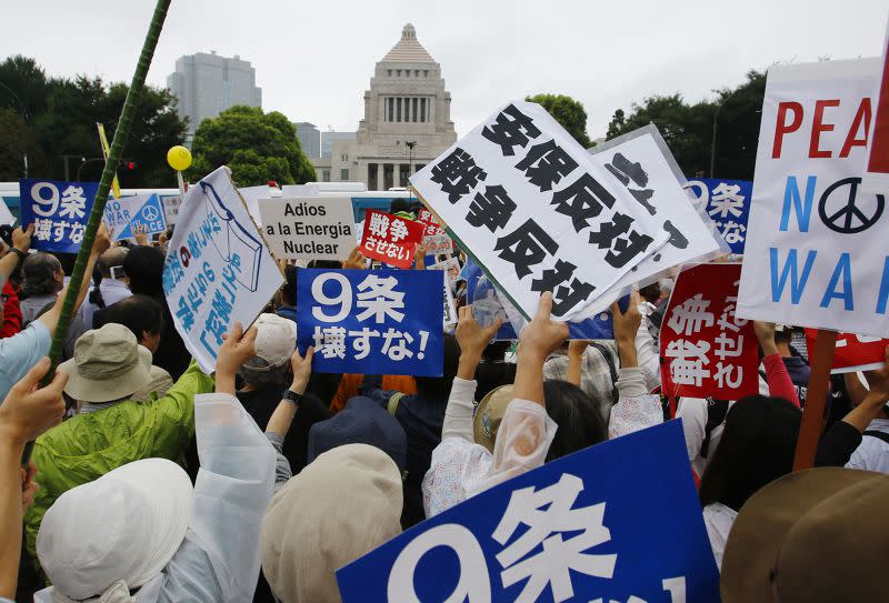 日本民眾冒雨包圍國繪，反對新安保法案。（美聯社）