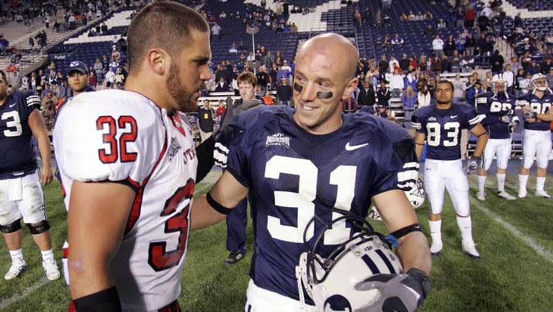 BYU’s Nathan Meikle, right, talks with Utah’s Eric Weddle after a game on Nov. 19, 2005, in Provo. Meikle is now an assistant professor at the University of Kansas.