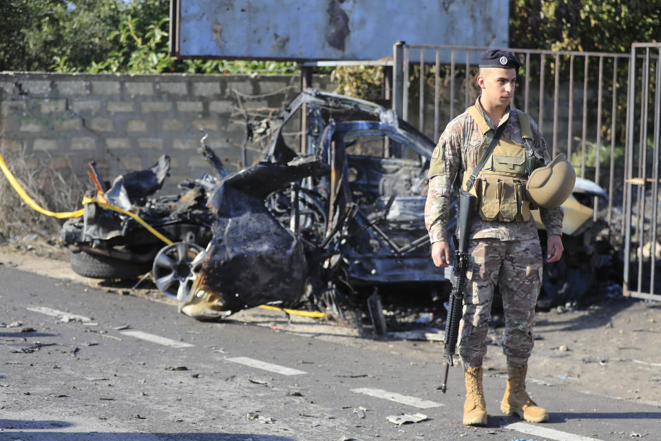 A Lebanese soldier stands next to a damaged car in the southern town of Bazouriyeh, Lebanon, Saturday, Jan. 20, 2024. An Israeli drone strike on the car near the Lebanese southern port city of Tyre killed two people, the state-run National News Agency reported. (AP Photo/Mohammad Zaatari)