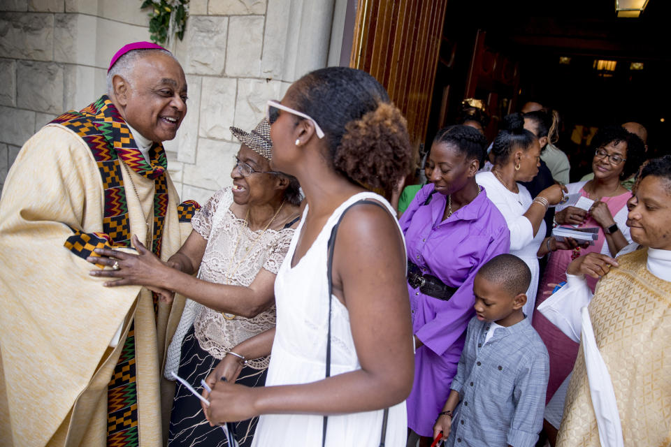 FILE - In this Sunday, June 2, 2019 file photo, Archbishop of Washington Wilton Gregory, left, greets parishioners following Mass at St. Augustine Church in Washington. In June 2020, Gregory, the first African-American in charge of the Archdiocese of Washington, joined with eight fellow bishops from his region to acknowledge the church’s “sins and failings” in regard to racial justice. “Prayer and dialogue, alone, are not enough. We must act to bring about true change,” the bishops said, calling for more racial equality in health care, education, housing and criminal justice. (AP Photo/Andrew Harnik)