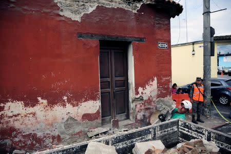 A municipal worker removes debris from a damaged house after an earthquake in Antigua, Guatemala June 22, 2017. REUTERS/Luis Echeverria